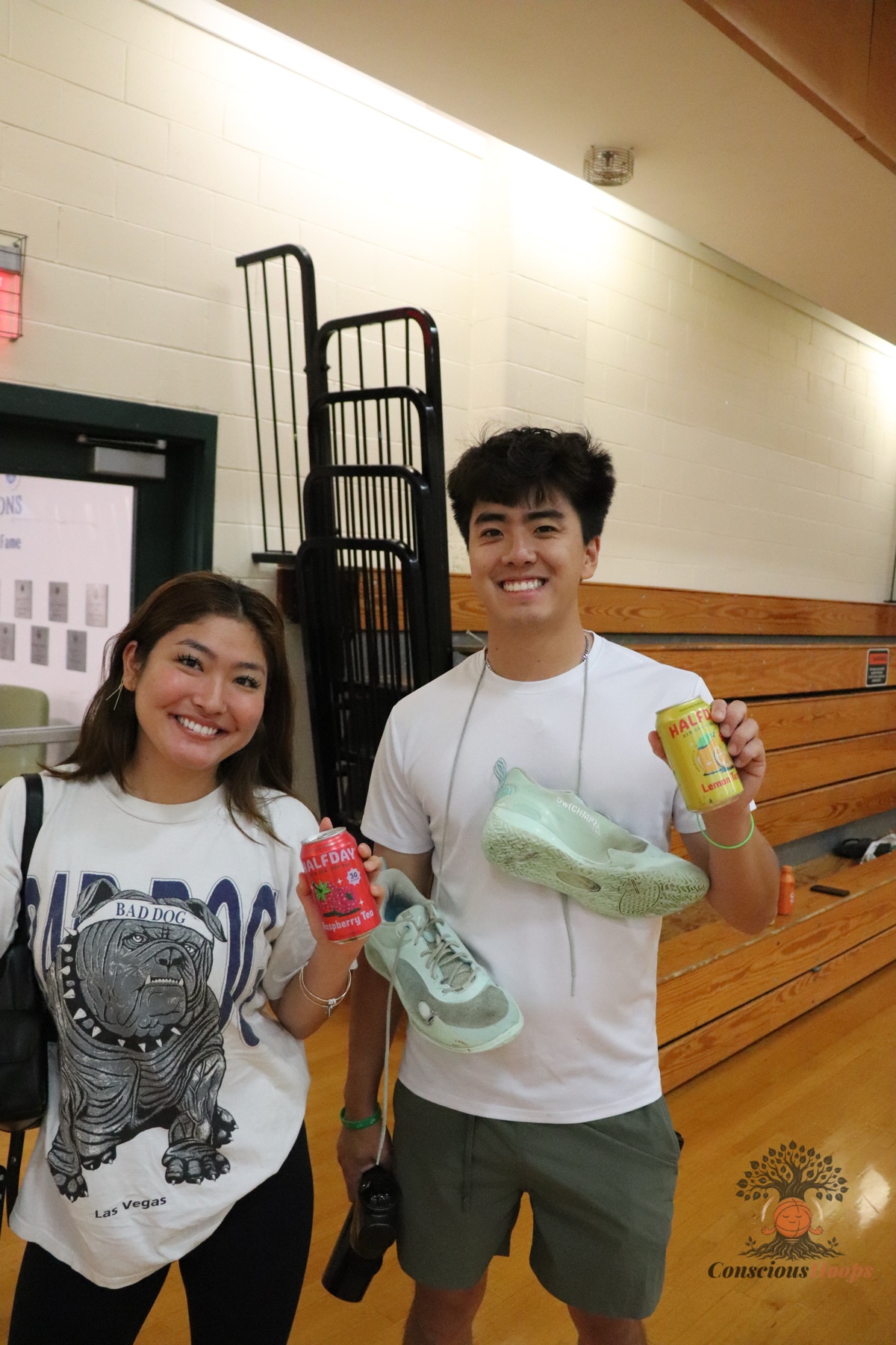 Two players holding drinks and basketball shoes after the session