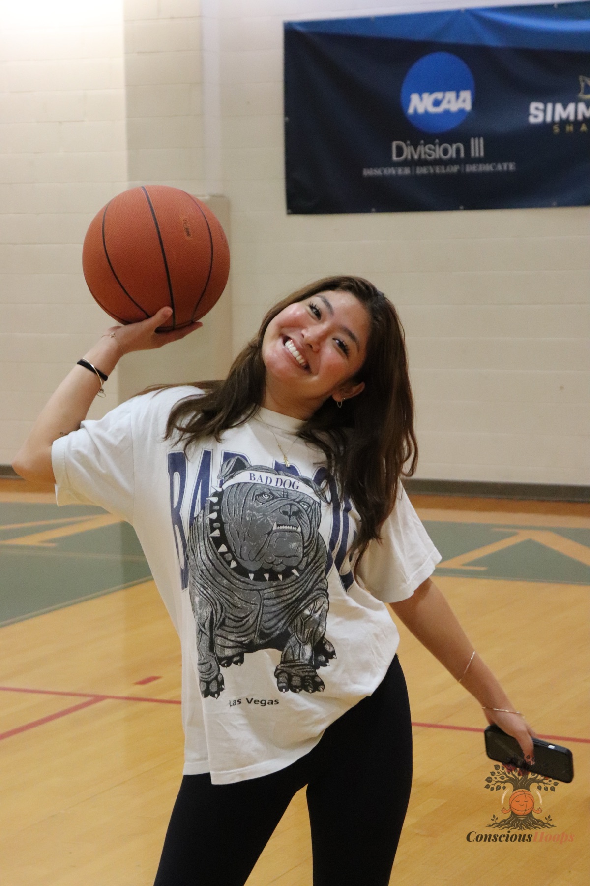 A player posing playfully with a basketball on the court